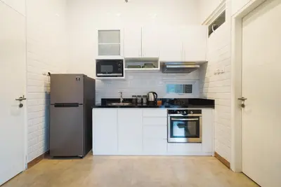 a kitchen with white cabinets and a stainless steel refrigerator at Umaja Villa in Seminyak