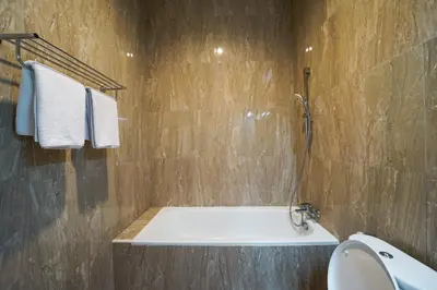 a bathroom with a bath tub and a toilet at Umaja Villa in Seminyak