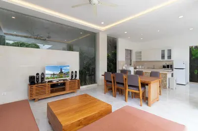 a living room with a dining table and a tv at Villa Kusamakura Seminyak in Seminyak