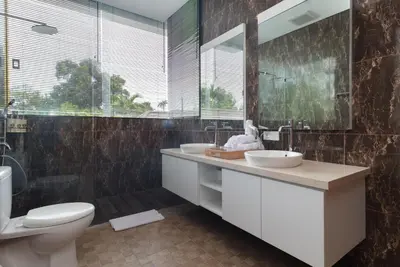a bathroom with two sinks and a toilet and a window at Villa Kusamakura Seminyak in Seminyak