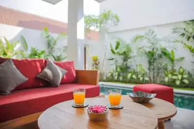 two glasses of orange juice on a table with a couch at Villa 66, 5 min walk to Double 6 beach in Seminyak