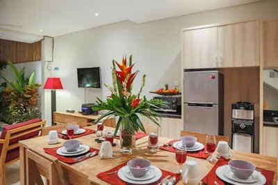 a kitchen with a wooden table with a vase of flowers at Villa 66, 5 min walk to Double 6 beach in Seminyak