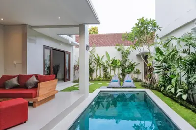 a pool in the backyard of a house with a red couch at Villa 66, 5 min walk to Double 6 beach in Seminyak