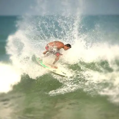 a man riding a wave on a surfboard in the ocean at Genta House in Kuta