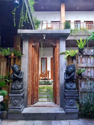 an entrance to a house with a door with statues at Genta House in Kuta