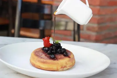 a doughnut with fruit on a plate on a table at Ossotel Legian in Legian