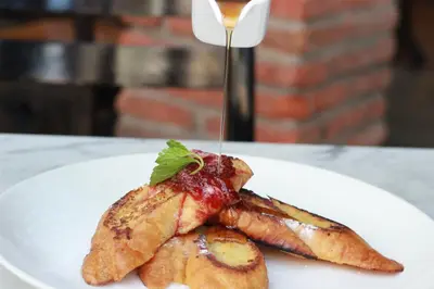 a white plate with a piece of food with a sauce at Ossotel Legian in Legian