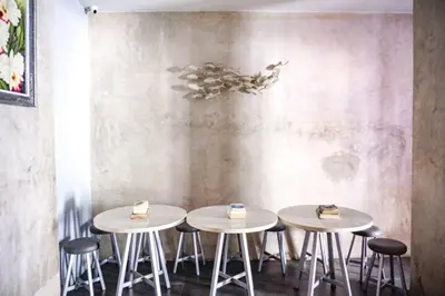 three tables in a room with cakes on them at RedDoorz Hostel Near Ngurah Rai Airport Kuta in Kuta