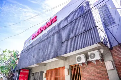 a building with a sign on the side of it at RedDoorz Hostel Near Ngurah Rai Airport Kuta in Kuta