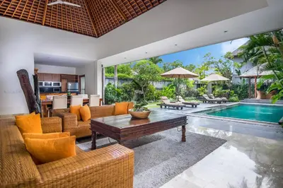 an indoor living room with a pool and a table at Serene Villas in Seminyak