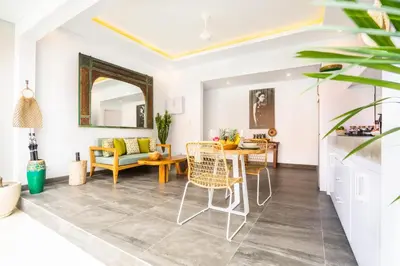 a living room with a table and chairs at Casa Su Seminyak in Seminyak