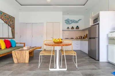 a kitchen and living room with a table and chairs at Casa Nisa Seminyak in Seminyak