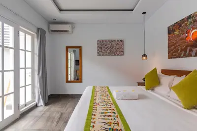 a bedroom with a bed and a large window at Casa Nisa Seminyak in Seminyak