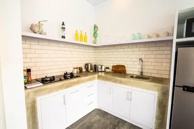 a kitchen with white cabinets and a sink at Casa Ku Seminyak in Seminyak