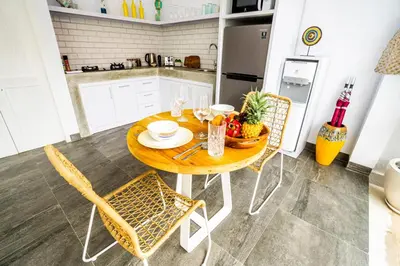 a kitchen with a wooden table and chairs in a kitchen at Casa Ku Seminyak in Seminyak