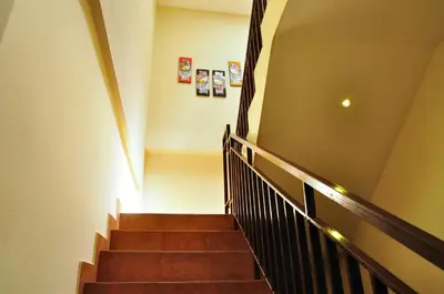 a staircase in a building with brown stairs at Kuta Sari House in Kuta