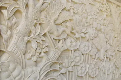a wall with a carving of flowers on it at Kuta Sari House in Kuta