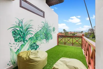 a balcony with a mural of plants on the wall at Saga Villas Legacy in Seminyak