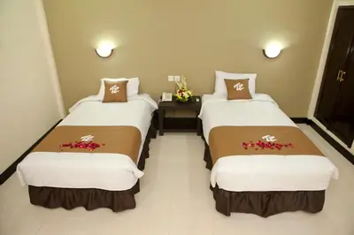 two beds in a hotel room with flowers on them at Troppo Zone Puri Rama Resort Kuta in Legian