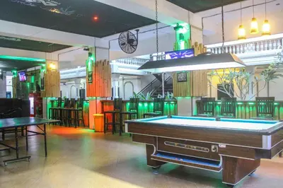 a pool table in a bar with green lighting at Troppo Zone Puri Rama Resort Kuta in Legian