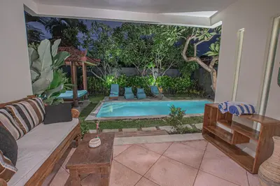 a living room with a swimming pool in a backyard at Leluhur 1 Private Pool Villa in Seminyak