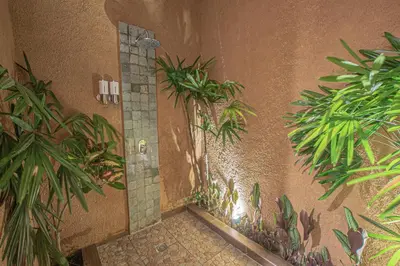a bathroom with a shower with plants on the wall at Leluhur 1 Private Pool Villa in Seminyak