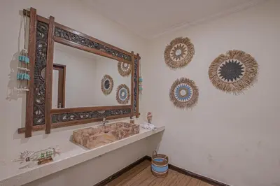 a bathroom with a sink and a mirror on the wall at Leluhur 1 Private Pool Villa in Seminyak