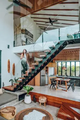 a woman is standing on the stairs of a house at Beyond Bespoke Villas in Seminyak