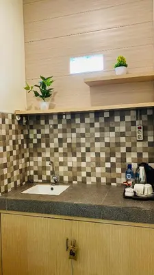 a kitchen counter with a sink and a tiled wall at Mailaku House in Kerobokan