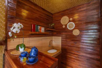 a wooden bathroom with a sink and a toilet at Mailaku House in Kerobokan