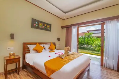 a bedroom with a bed with a teddy bear on it at Mailaku House in Kerobokan