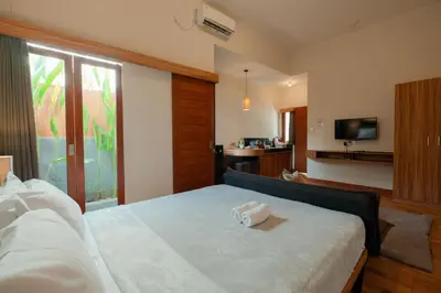 a hotel room with a bed and a television at Andewi Guest House Denpasar RedPartner - Minimum Stay 30 Nights in Sanur