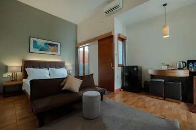 a living room with a bed and a couch in it at Andewi Guest House Denpasar RedPartner - Minimum Stay 30 Nights in Sanur