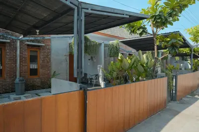 a house with a wooden fence and a wooden pergola at Andewi Guest House Denpasar RedPartner - Minimum Stay 30 Nights in Sanur
