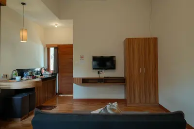 a living room with a couch and a kitchen with a tv at Andewi Guest House Denpasar RedPartner - Minimum Stay 30 Nights in Sanur