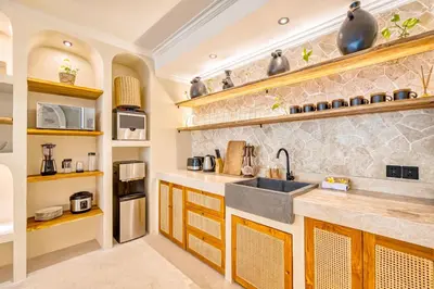 a kitchen with wooden cabinets and a sink at Villa Aurora - Private 6 BDR Villa in Seminyak, prime Location, Pool & Garden in Seminyak
