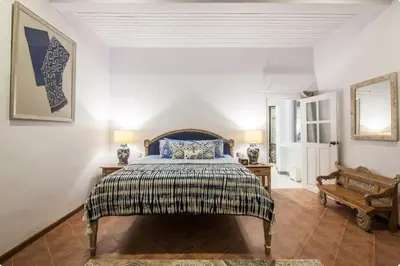 a bedroom with a bed and two lamps and a mirror at Villa Alexandra Seminyak By Island Escape in Seminyak