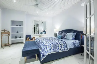 a bedroom with a blue bed and a mirror at Villa Alexandra Seminyak By Island Escape in Seminyak