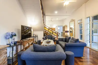 a living room with blue couches and a tv at Villa Alexandra Seminyak By Island Escape in Seminyak