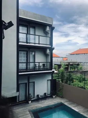 a apartment building with a swimming pool in front of it at Rumah Kahyangan in Canggu