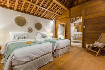 two beds in a room with wooden walls at Villa KIU by Alfred in Bali in Seminyak