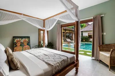 a bedroom with a canopy bed and a pool at Villa Nabi by Alfred in Bali in Seminyak