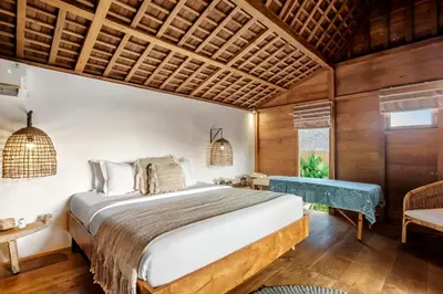 a bedroom with a large bed and a wooden ceiling at Villa Nabi by Alfred in Bali in Seminyak