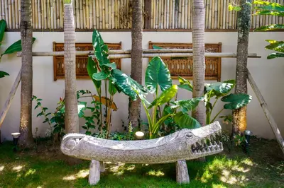 a garden with a fake crocodile in the grass at Villa Nabi by Alfred in Bali in Seminyak