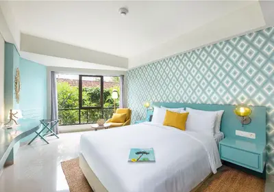 a blue and white bedroom with a bed and a window at MAMAKA by Ovolo in Kuta