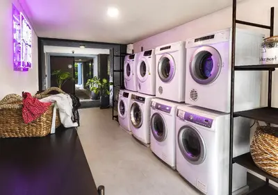 a laundry room with four washers and dryers at MAMAKA by Ovolo in Kuta