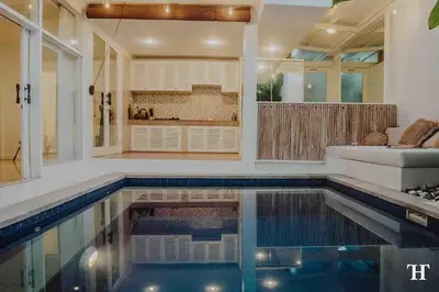 a swimming pool in a living room with a couch at THE HIDDEN TREE CANGGU 100 meter to beach in Canggu