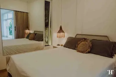a bedroom with two beds and a large window at THE HIDDEN TREE CANGGU 100 meter to beach in Canggu