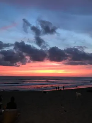 a group of people on a beach at sunset at THE HIDDEN TREE CANGGU 100 meter to beach in Canggu