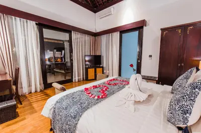a bedroom with a large bed with a red flower on it at Aldeoz Grand Kancana Villas Resort Bali in Kerobokan